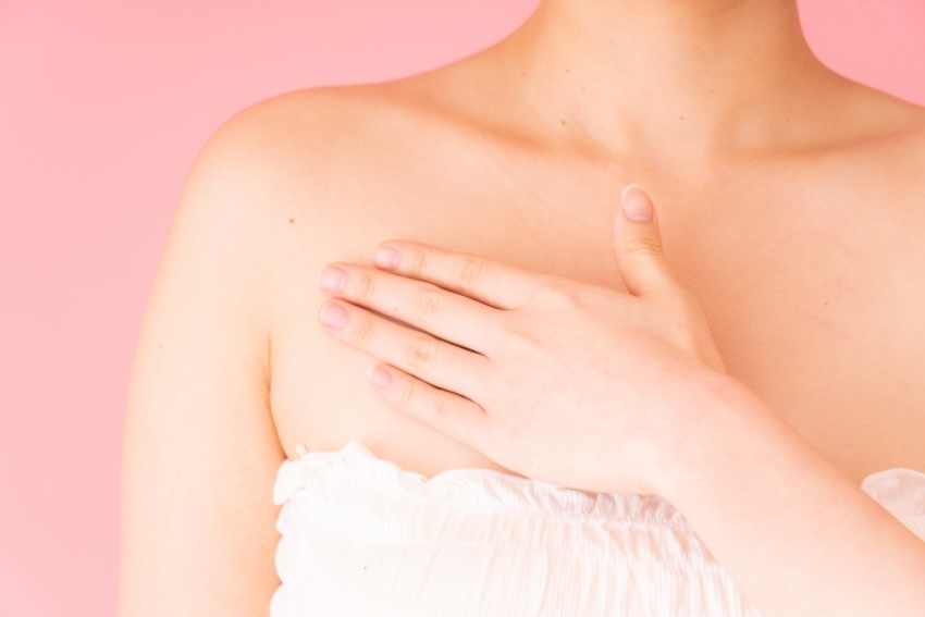 胸部を抑える女性の写真